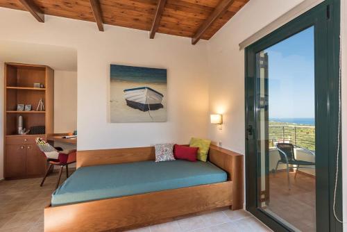 a room with a couch and a view of the ocean at Margarita's Villas in Chania