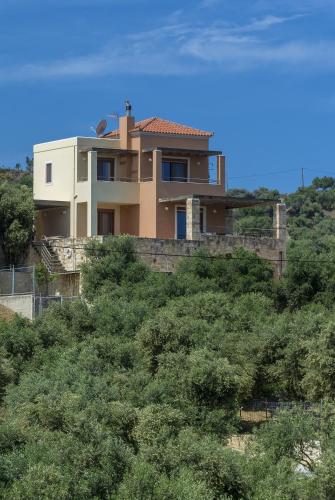 a house on top of a hill with trees at Margarita's Villas in Chania Town