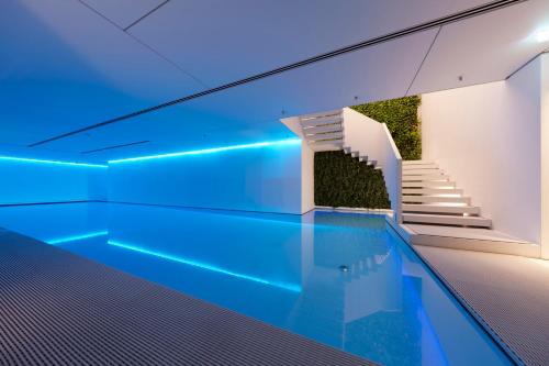 a swimming pool with a blue floor and blue walls at Conservatorium Hotel in Amsterdam