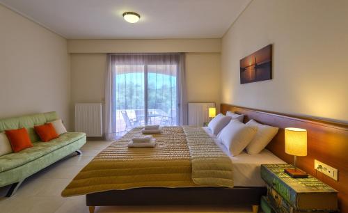 a bedroom with a large bed and a couch at Margarita's Villas in Chania Town