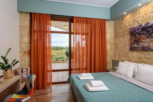 a bedroom with a bed and a large window at Margarita's Villas in Chania Town