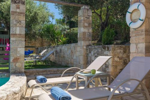a patio with chairs and a swimming pool at Margarita's Villas in Chania Town