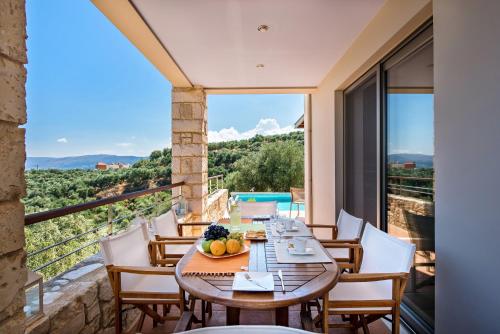 a dining room with a table and chairs on a balcony at Margarita's Villas in Chania Town