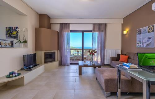 a living room with a couch and a table with a laptop at Margarita's Villas in Chania Town