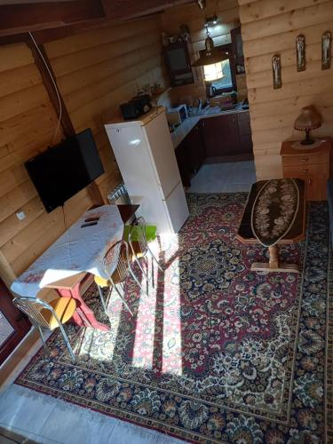 a living room with a refrigerator and a table and chairs at Mroczkówka in Dębowiec