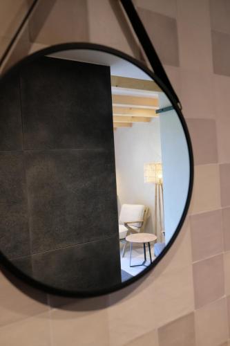 um espelho num quarto com uma mesa e uma cadeira em Bed & Wijn - Suite 1 em Staphorst