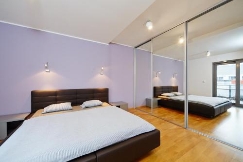 a bedroom with two beds and a mirror at Anenské terasy in Brno
