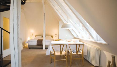 a bedroom with a bed and a table and chairs at Hotel Haus Norderney in Norderney