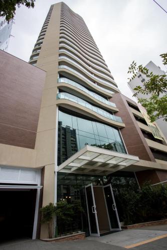 a tall building with a revolving door in front of it at Estanconfor Santos Vista Mar 4 AC Garagem sacada fechada in Santos