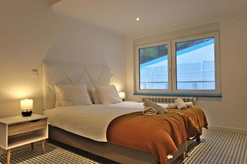 A bed or beds in a room at Mega Ocean Magoito - Guest House - Sintra