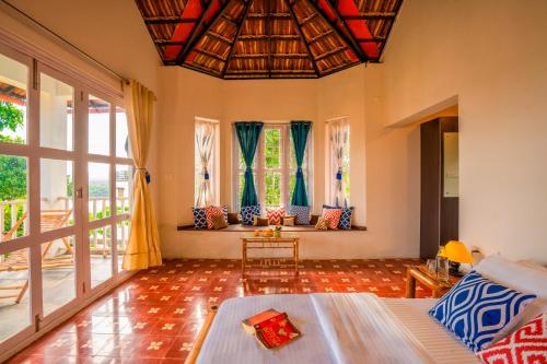 a living room with a couch and some windows at Zostel Homes Wayanad (Karapuzha) in Wayanad