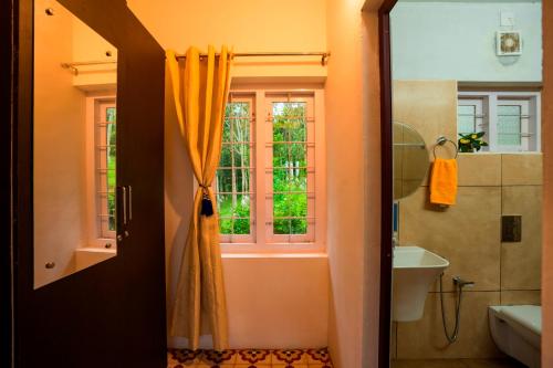 a bathroom with a shower and a window at Zostel Homes Wayanad (Karapuzha) in Wayanad