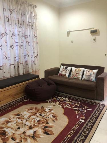 a living room with a couch and a rug at HOMESTAY SERI LAZUARDI 3 MACHANG ISLAMIC in Machang