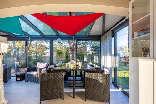 une véranda avec une salle à manger dotée d'un plafond en verre dans l'établissement Gawa's House, à Meschers-sur-Gironde