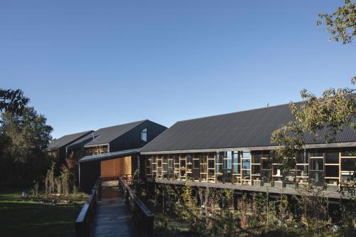 a building with a wooden walkway in front of it at Hotel & Cava Estancia Rilán in Castro