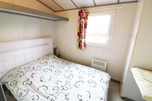 ein kleines Schlafzimmer mit einem Bett und einem Fenster in der Unterkunft Camping La Tentation in Renty