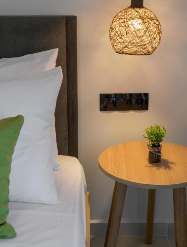 a bedroom with a bed and a table with a potted plant at Aegean Breeze Luxury Apartments next to the sea in Maleme