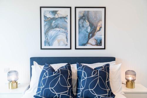 een slaapkamer met drie ingelijste foto's boven een bed bij Deluxe 1 Bedroom Stylish Apartment - City Centre in Birmingham