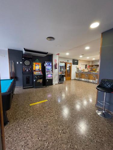 a room with a pool table and two arcade machines at Hotel Reina Isabel in Lleida