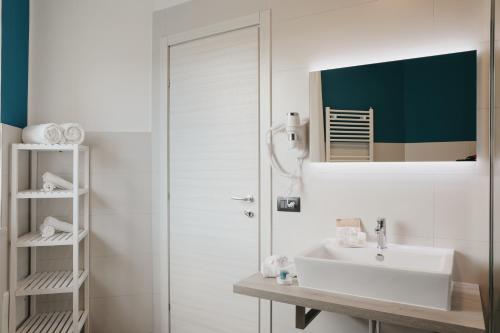 a white bathroom with a sink and a mirror at Residence Vazzieri in Campobasso
