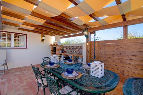 a patio with a table and chairs and a wooden wall at Villa Oliva Al ii in Moncarapacho