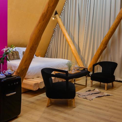 a bedroom with a bed and two chairs and a table at 3 Hills Boutique - The Ranch Experience in Trílofos