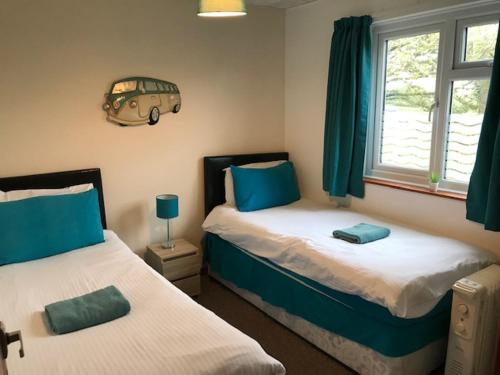 a bedroom with two beds with blue and white at Wheal Rodney Holiday Park in Marazion