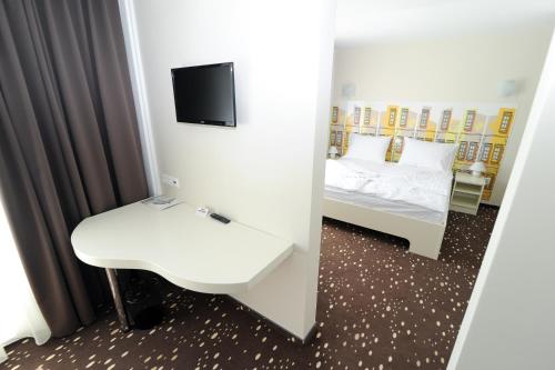 a mirror of a room with a bed and a tv at City Hotel Krško in Krško
