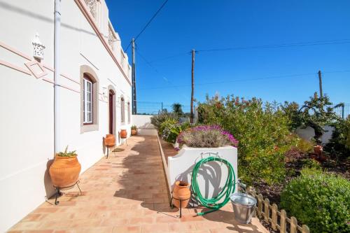 a walkway with a green hose next to a building at Villa Oliva Al in Moncarapacho
