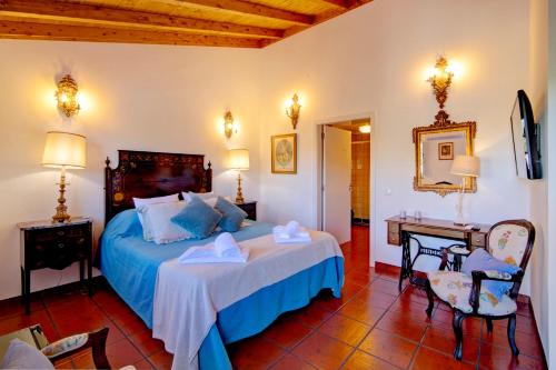a bedroom with a bed and a table and a chair at Villa Oliva Al in Moncarapacho