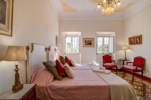 a bedroom with a large bed with red pillows at Villa Oliva Al in Moncarapacho