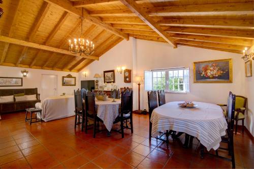a dining room with two tables and a couch at Villa Oliva Al in Moncarapacho