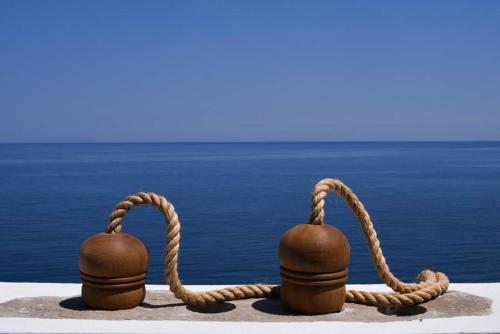 two bells with a rope next to the water at Toxotis Villas in Armenistis