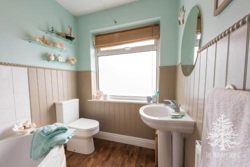 a bathroom with a white toilet and a sink at The Monkey House B&B in Stone