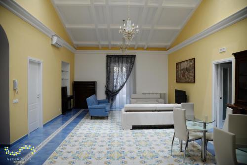 un soggiorno con un divano, un tavolo e delle sedie di Arte & Mare a Patti