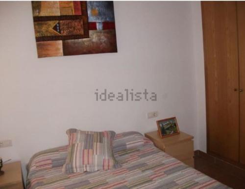 a bedroom with a bed and a sign on the wall at Precioso apartamento 1ª linea playa con piscina in Vinarós