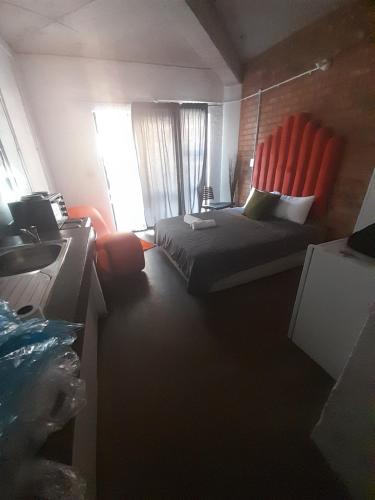 sypialnia z łóżkiem i pomarańczowym krzesłem w obiekcie Relax In Maboneng w mieście Johannesburg
