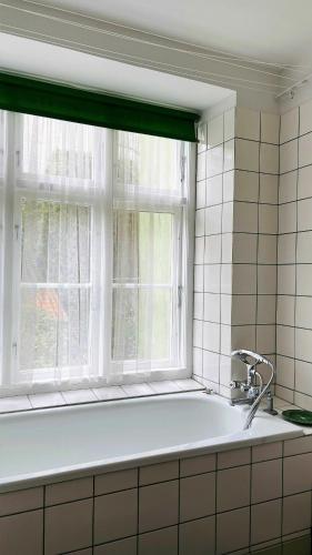 a bath tub in a kitchen with a window at ApartmentInCopenhagen Apartment 1466 in Copenhagen