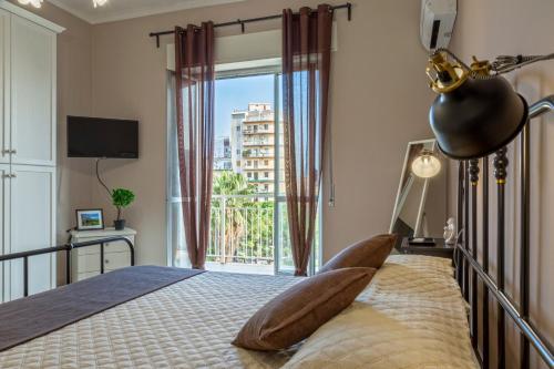 a bedroom with a bed and a large window at AliceA apartment in Siracusa in Siracusa