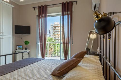 a bedroom with a bed and a large window at AliceA apartment in Siracusa in Syracuse