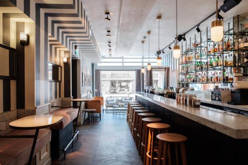 a restaurant with a bar with wooden stools at Morgan & Mees Amsterdam in Amsterdam