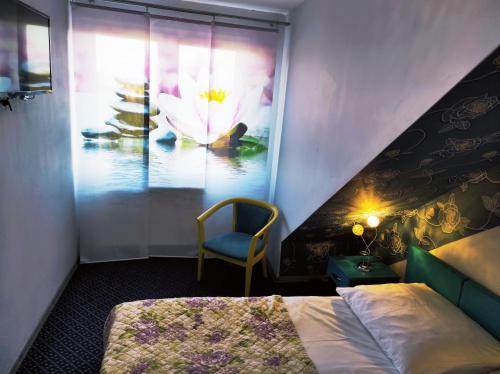 sypialnia z łóżkiem i oknem z malowidłem kwiatowym w obiekcie Pod Różą B&B w Ustce