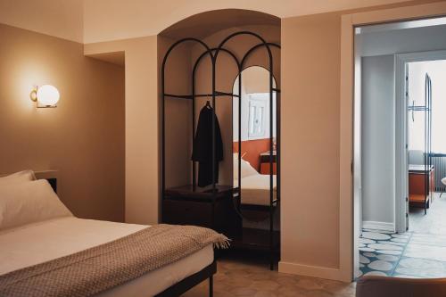 a bedroom with a bed and a mirror at Volante Urban Design Hotel in Santeramo in Colle