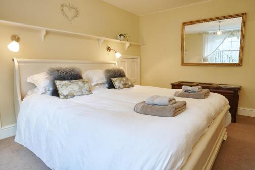 a bedroom with a large white bed with towels on it at Southcot Place, Apartment With Garden in Bath