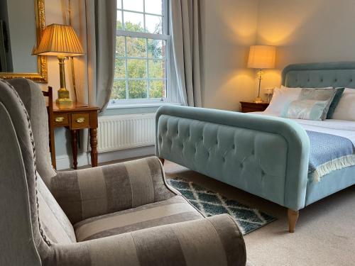 a bedroom with a bed and a couch and a chair at The Broomsquire in Aldermaston