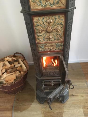 a wood burning stove with a basket of wood at Ferienwohnung Jacobshof in Oberstedem