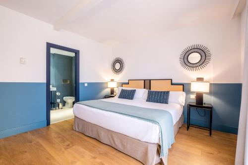 a bedroom with a large white bed and blue walls at Soho Boutique Las Vegas in Málaga