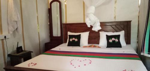 シギリヤにあるSigiri Panaromic Tree Houseのベッドルーム1室(花の飾られたベッド1台付)