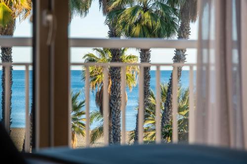 
a view from a balcony of a beach with palm trees at Soho Boutique Las Vegas in Málaga
