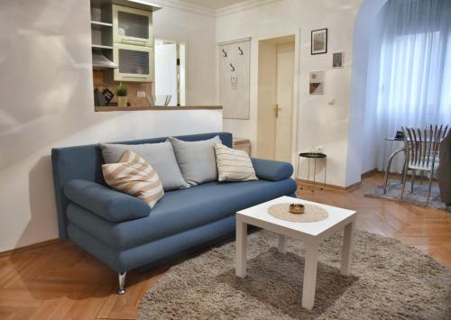 - un canapé bleu dans le salon avec une table dans l'établissement Apartment Carpe diem in Belgrade, à Belgrade